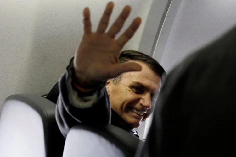 Jair Bolsonaro em voo entre São Paulo e Rio de Janeiro: com bandeiras de apoio ao candidato e usando roupas verdes e amarelas, o grupo era pequeno, mas ruidoso (Leonardo Benassatto/Reuters)