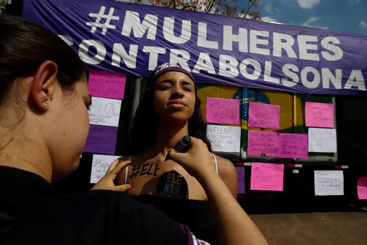 Mulher pinta o dizer "Ele não" durante protesto contra Jair Bolsonaro em São Paulo: no Brasil, há pelo menos 60 atos agendados (Alexandre Schneider/Reuters)