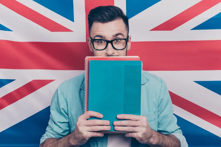 Homem estudando inglês na frente da bandeira do Reino Unido (Deagreez/Getty Images)