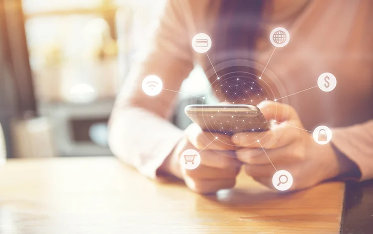 Woman hand holding smart phone with graphic icon multichannel online banking payment network communication (oatawa/iStockphoto)