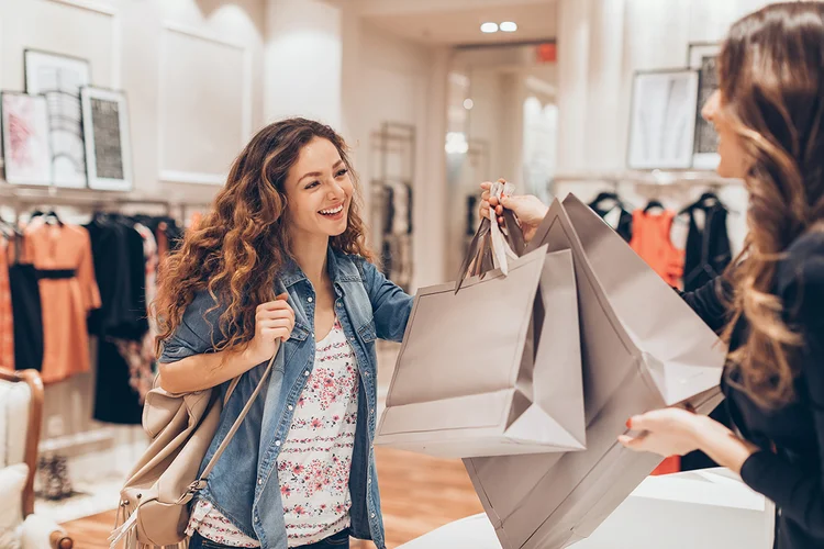 Young woman taking her shopping bags in a fashion store (pixelfit/iStockphoto)