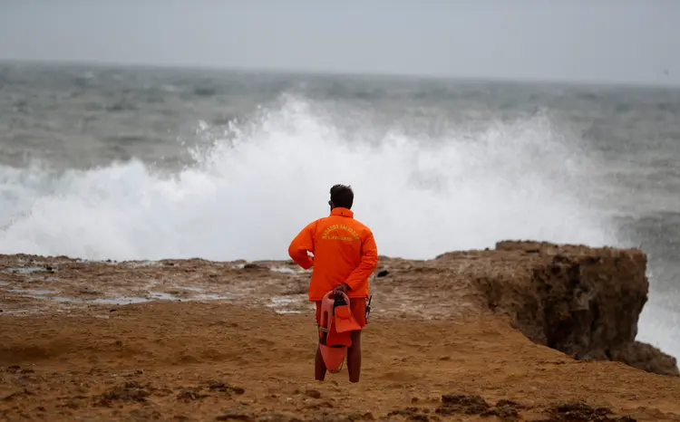 Um salva-vidas vê o mar na praia Carcavelos, em Portugal, antes da tormenta Leslie chegar (Rafael Marchante/Reuters)