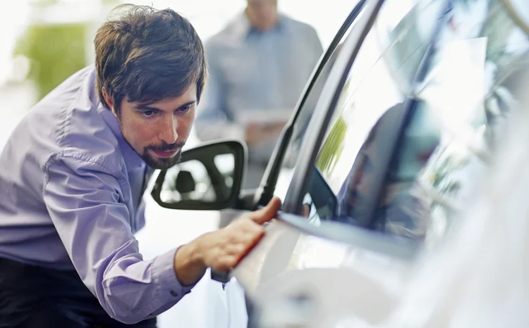 Comprador examinando carro: cuidados ajudam a diminuir a desvalorização do carro, que é alta (Westend61/Getty Images)