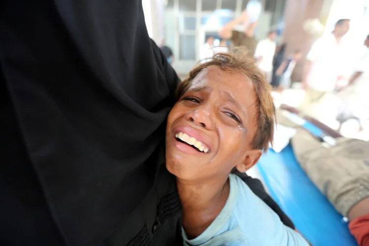 Menino chora depois que seu irmão foi ferido durante um ataque próximo ao hospital al-Thawra em Hodeidah, no Iêmen (Abduljabbar Zeyad/File Photo/Reuters)
