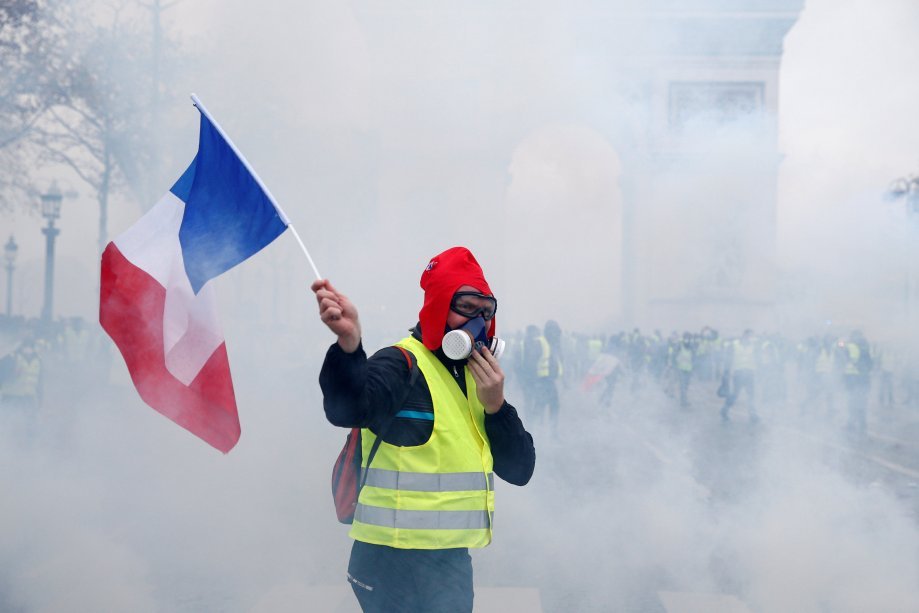 Manifestante seguran bandeira da França durante protestos contra o aumento dos preço dos combustíveis
