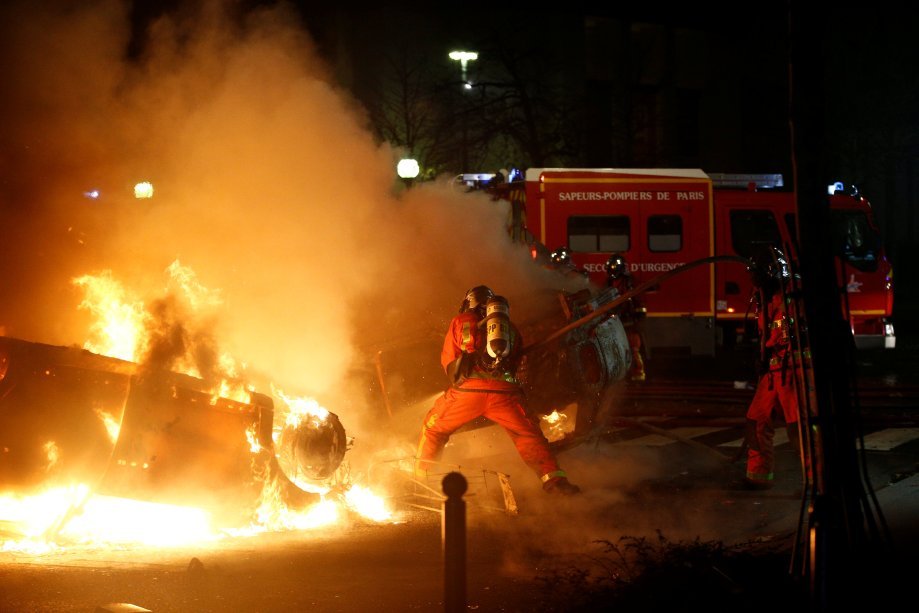 Bombeiros tentam controlar o fogo de veículos queimados pelos manifestantes na França