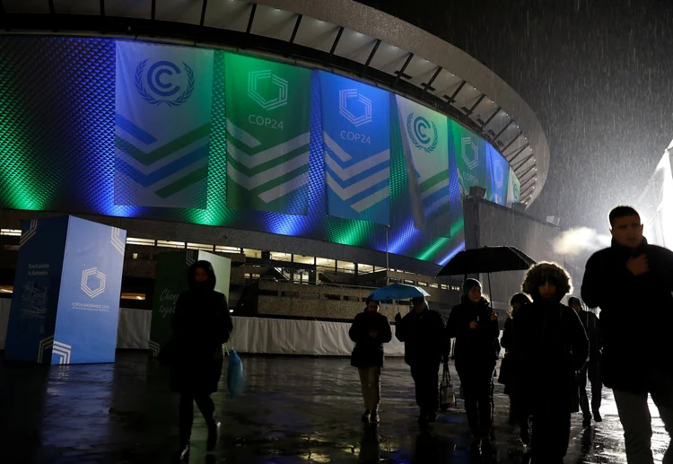 Pessoas andando em frente ao local da Conferência das Nações Unidas sobre Mudança Climática COP24, em 2018, em Katowice, Polônia (Kacper Pempel/Reuters)
