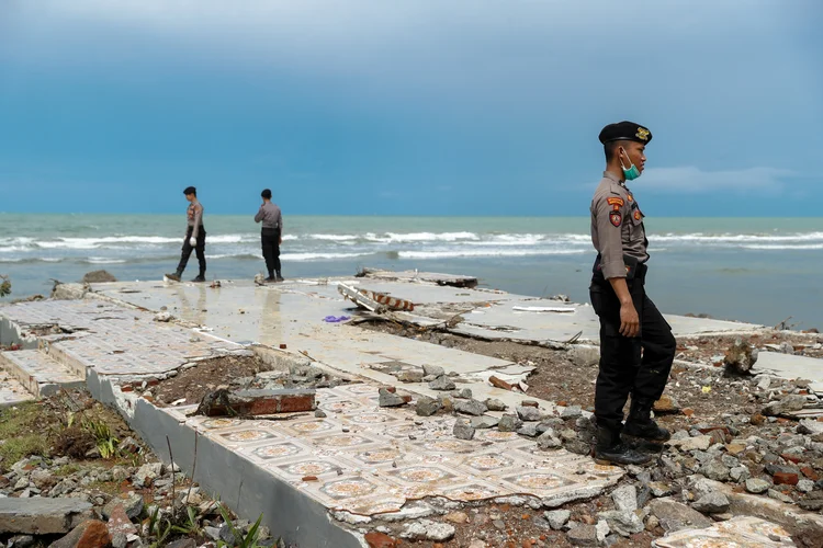 Tsunami na Indonésia: Policiais procuram vítimas entre os escombros de um hotel destruído em frente à praia atingida (Jorge Silva/Reuters)