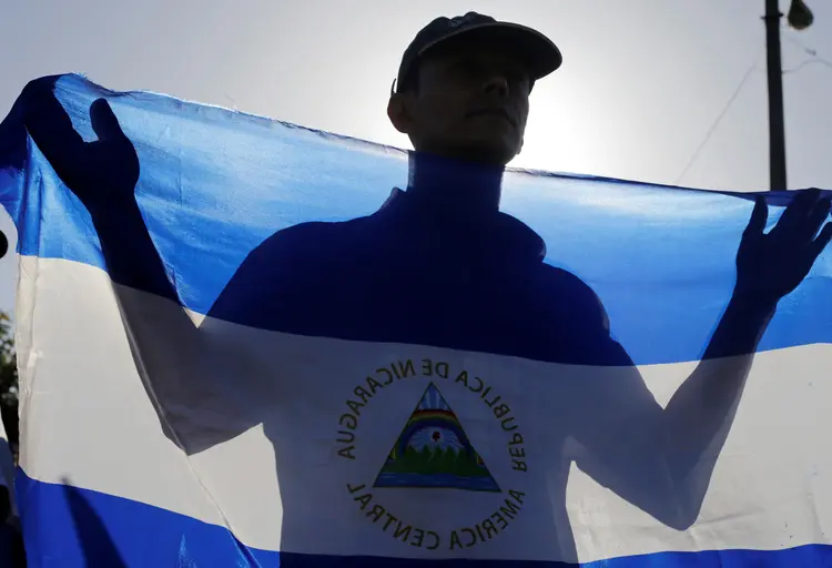 Homem segura bandeira da Nicarágua  (Oswaldo Rivas/Reuters)