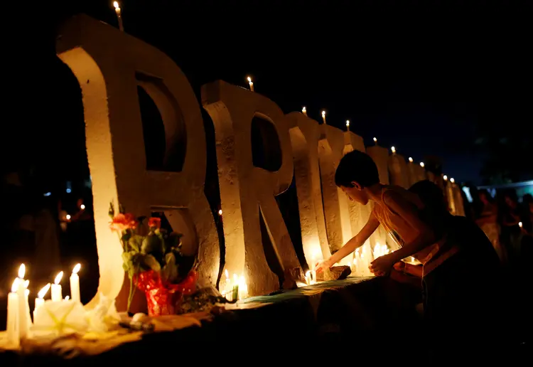 Brumadinho: pessoas acendem velas no letreiro localizado na entrada da cidade mineira arrasada por desastre ambiental (Adriano Machado/Reuters)