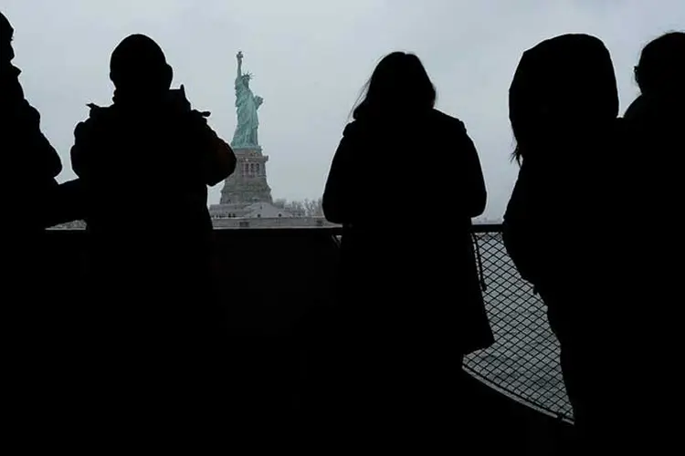 Terra das oportunidades: pessoas observam a estátua da liberdade. (Spencer Platt/Getty Images)