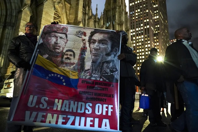 Manhattan, Nova York: manifestação de apoiadores de Nicolás Maduro seguram uma bandeira com imagens do falecido ex-presidente da Venezuela Hugo Chavez, do próprio Maduro e do líder militar Simon Bolívar (Drew Angerer/Getty Images)