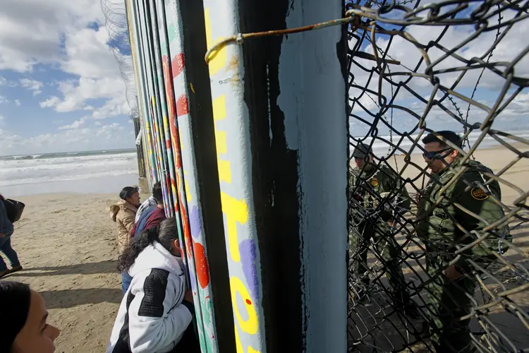 Fronteira México-EUA: os agentes da patrulha fronteiriça e os visitantes ao longo da cerca em Tijuana (Sandy Huffaker/Getty Images)