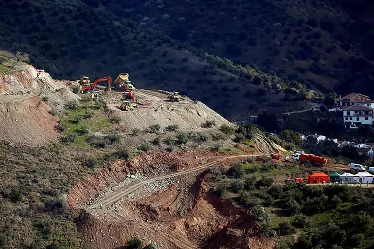 Escavadores e caminhões removem areia na área onde o menino espanhol de dois anos caiu em um poço. (Jon Nazca/Reuters)