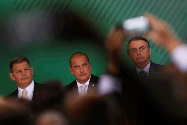 Onyx Lorenzoni, ministro da Casa Civil, entre o presidente Bolsonaro e o vice general Mourão (Adriano Machado/Reuters)