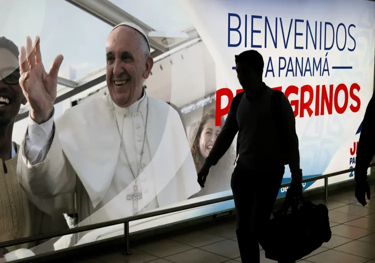 Passageiro passa por pôster com a foto do Papa Francisco no aeroporto de Tocumen, no Panamá (Henry Romero/Reuters)