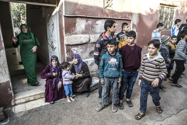 Idlib, Síria: mulheres e crianças são tentam retomar a vida após ataque químico das forças do regime de Assad no distrito de Khan Shaykhun de Idlib, em 2 de dezembro de 2018 (Cem Genco/Anadolu Agency/Getty Images)