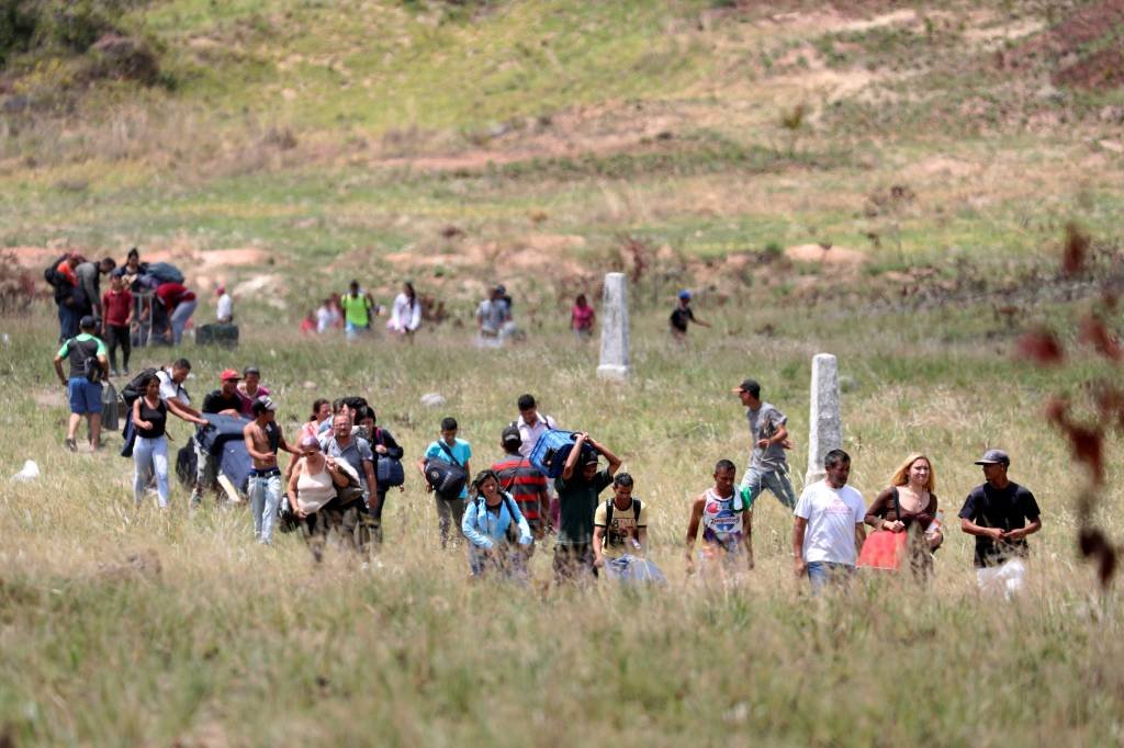 Venezuelanos cruzando a fronteira do país com o Brasil: no país, existem 300 mil refugiados, de diversas nacionalidades (Ricardo Moraes/Reuters)