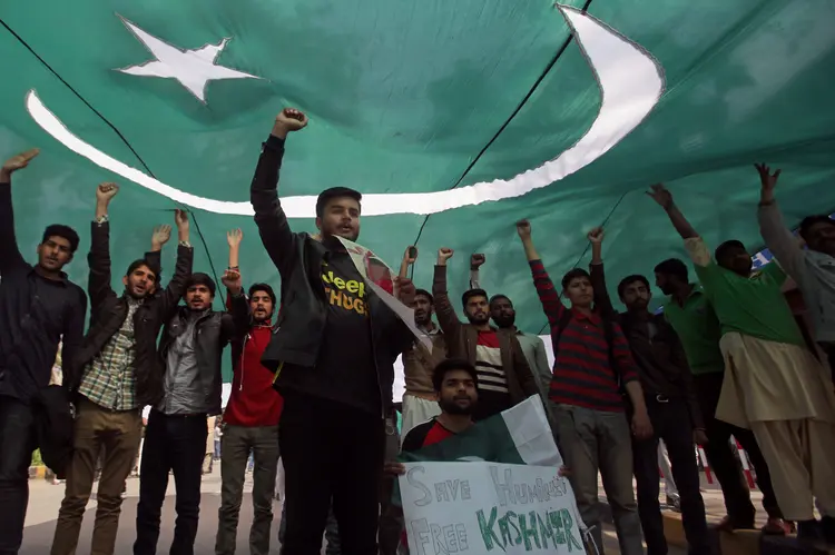 Paquistão: estudantes entoam slogans sob a sombra da bandeira nacional, depois que o Paquistão abateu duas aeronaves militares indianas, segundo autoridades paquistanesas, durante uma passeata em Lahore (Mohsin Raza/Reuters)
