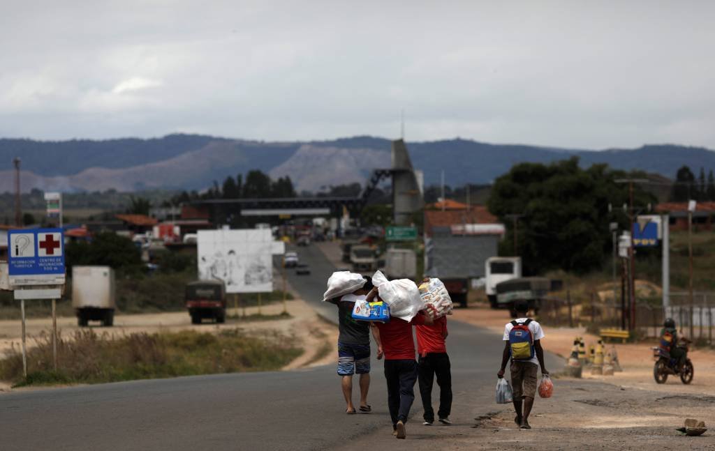 Venezuelanos voltam a seu país depois de comprar comida na cidade de Pacaraima, no estado de Roraima (Ricardo Moraes/Reuters)