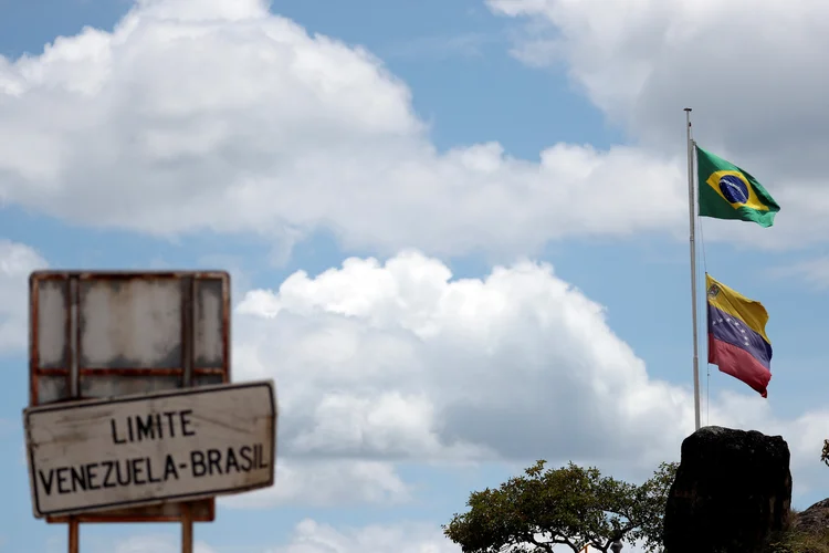 As bandeiras do Brasil e da Venezuela são vistas na fronteira: região foi marcada por conflitos no fim de semana (Ricardo Moraes/Reuters)