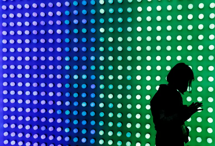 A visitor uses a mobile phone next to a Led Smart Bulb panel inside the Xiaomi booth at the Mobile World Congress in Barcelona, Spain February 25, 2019. REUTERS/Rafael Marchante (Rafael Marchante/Reuters)