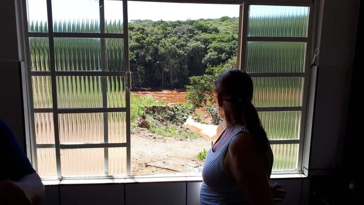 Brumadinho (MG): moradora observa o local tomado pela lama, da janela de sua casa . (Ana Graziela/Agência Brasil)
