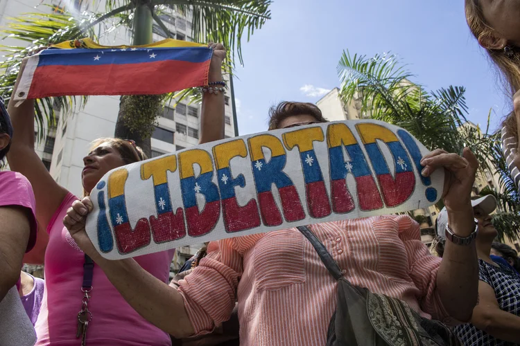 Caracas, Venezuela: manifestantes contrários a Maduro seguram um cartaz onde se lê "liberdade!" (Rayner Pena/picture alliance/Getty Images)