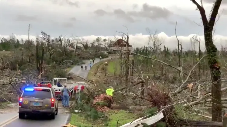 Pessoas limpam destroços e árvores caídas em estrada após a passagem de um tornado em Beauregard, Alabama, nos Estados Unidos, em 3 de março de 2019. (Scott Fillmer/Reuters)