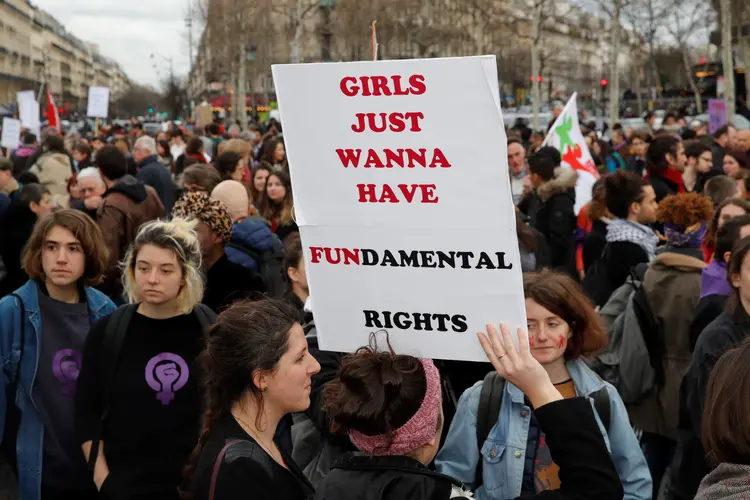 Mulheres protestam em Paris e carregam uma placa que diz "garotas só querem ter direitos fundamentais", uma brincadeira com a música "Girls Just Wanna Have Fun" (Philippe Wojazer/Reuters)