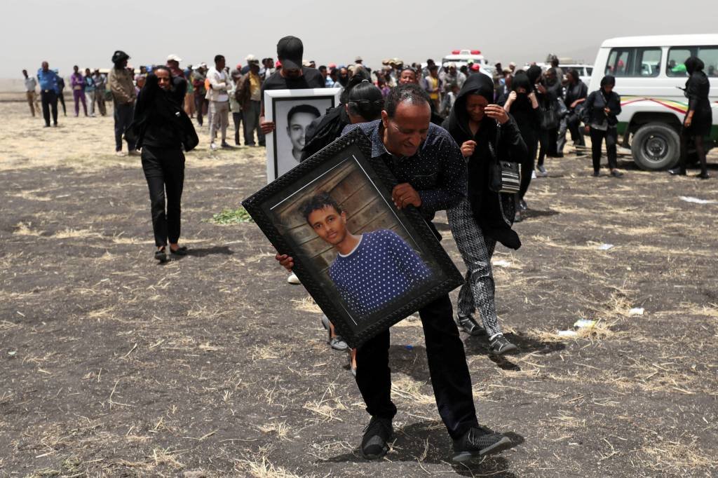 Tragédia aérea: parente carrega uma fotografia de retrato do piloto da Ethiopian Airlines Yared Getachew enquanto ele chora na cena do acidente. 14 de março de 2019 (Tiksa Negeri/Reuters)