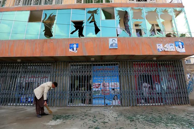 Ataque em Cabul: homem recolhe estilhaços de vidro após atentado nesta quinta-feira (21) (Parwiz/Reuters)