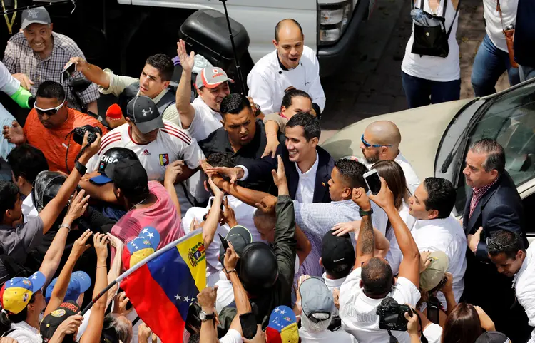 O líder da oposição venezuelana, Juan Guaido, que muitos países reconheceram como o legítimo governante interino do país, cumprimenta os partidários durante uma manifestação contra o governo do presidente venezuelano Nicolás Maduro em Caracas (Manaure Quintero/Reuters)