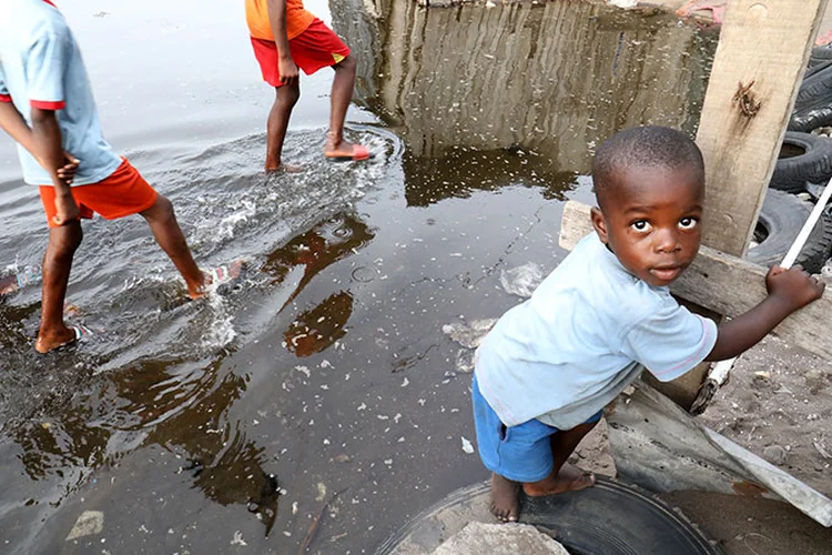 Costa do Marfim: crianças caminham por lagoa poluída em  Abidjan. (Thierry Gouegnon/Reuters)