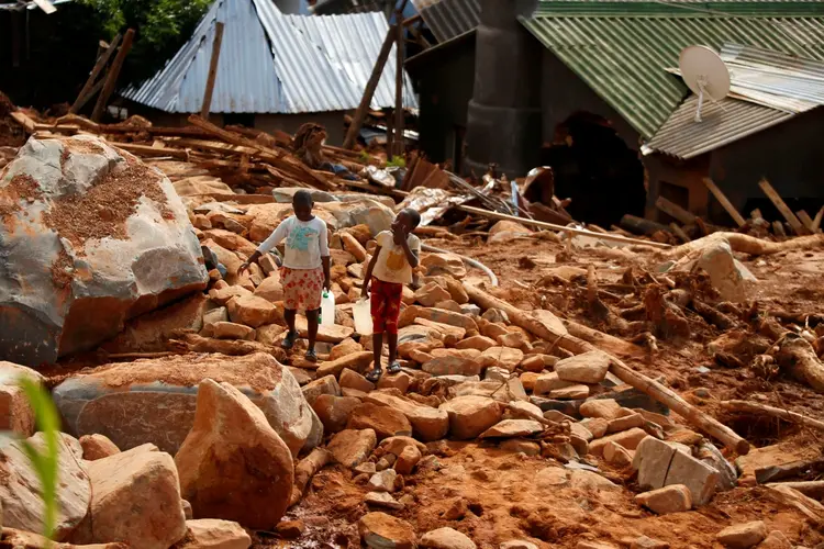 Crianças carregam água após os efeitos do ciclone Idai (Philimon/Reuters)