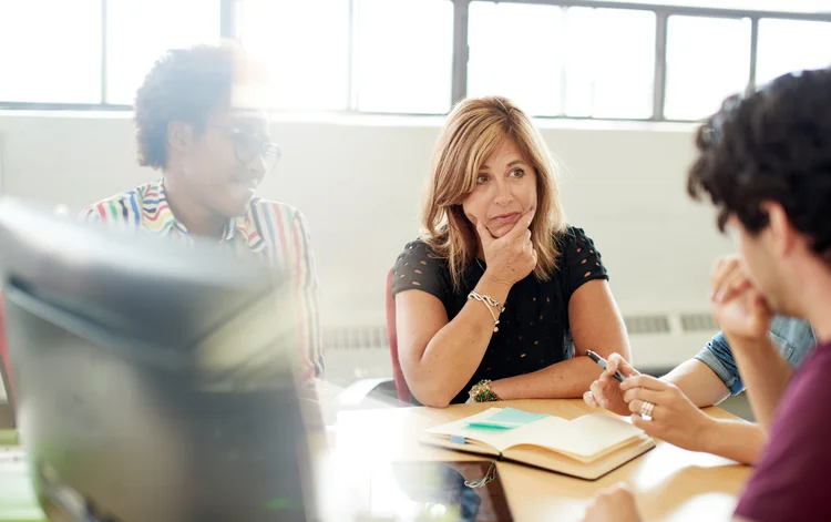 Candid picture of a female boss and business team collaborating. Filtered serie with light flares, bokeh, warm sunny tones. (foto/Thinkstock)