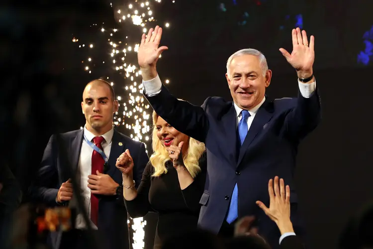 O primeiro-ministro israelense, Benjamin Netanyahu, e sua esposa, Sara, acenam após o anúncio de pesquisas de boca-de-urna nas eleições parlamentares de Israel na sede do partido em Tel Aviv, Israel (Ammar Awad/Reuters)