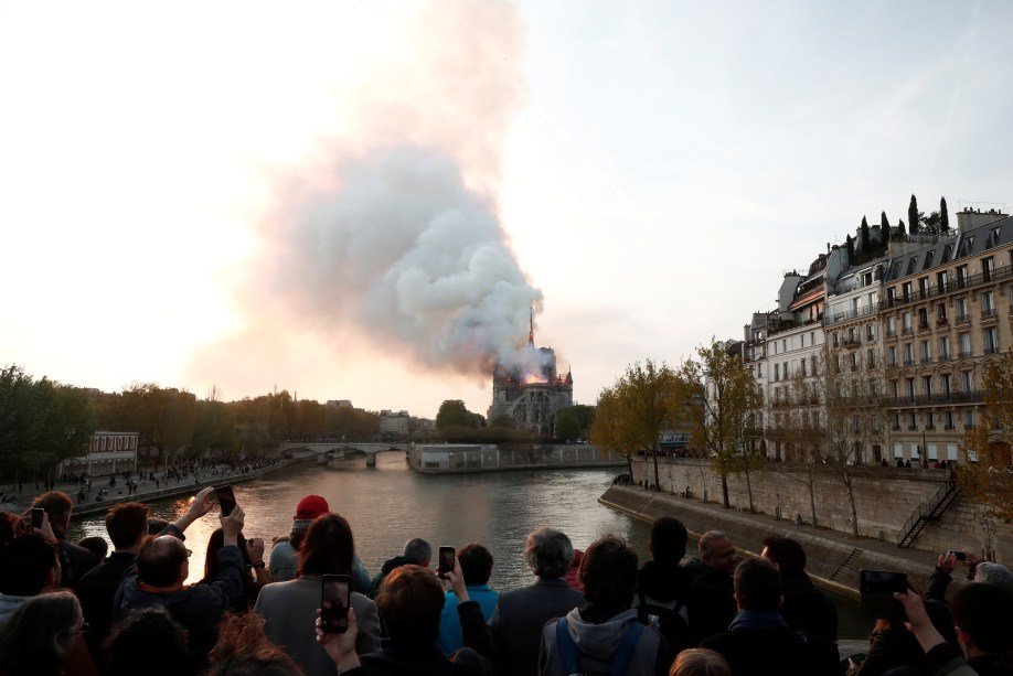 Pessoas se aproximam da catedral de Notre-Dame para ver o incêndio.