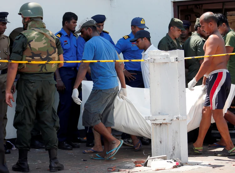 Homens carregam corpo de vítima dos atentados em Sri Lanka (Dinuka Liyanawatte/Reuters)