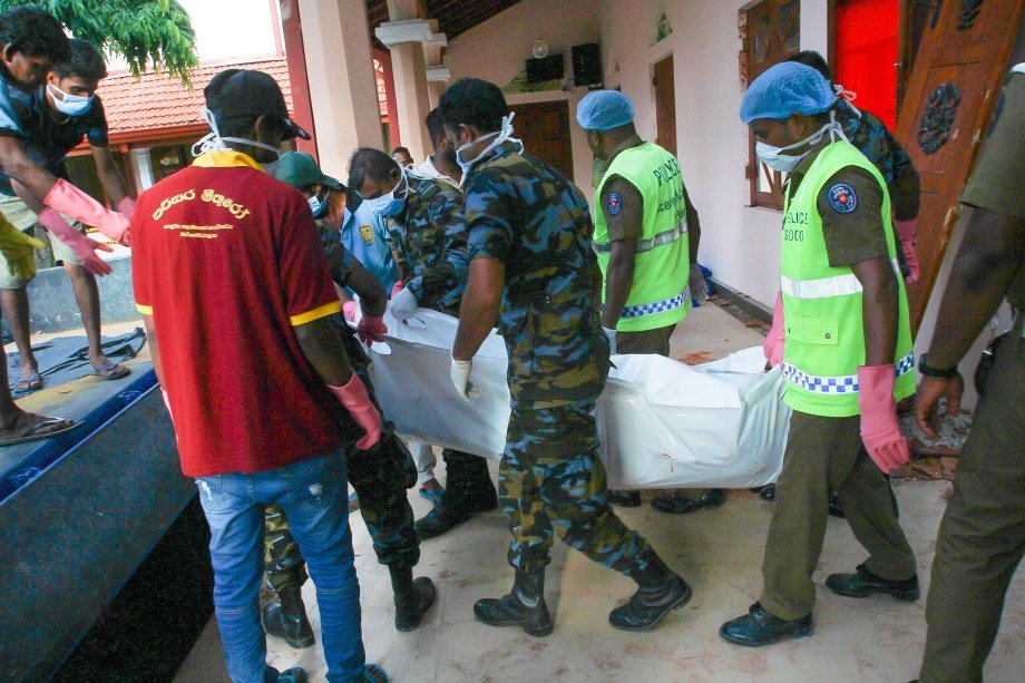 Homens carregam corpo de vítima dos ataques no Sri Lanka