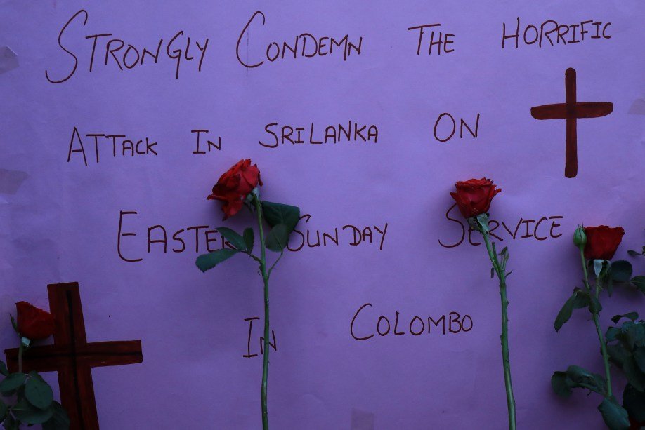Cartaz e rosas em frente à igreja em Peshawar, no Sri Lanka, demonstram solidariedade às vítimas de ataques