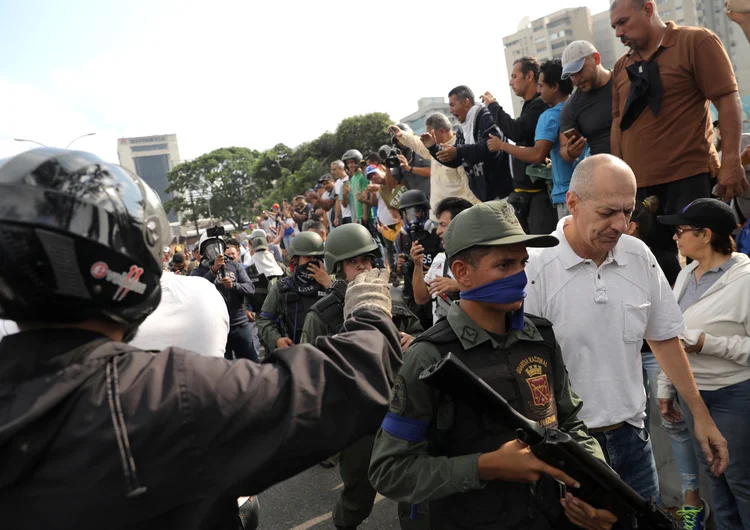 Venezuelanos reagem a presença de militares na manifestação em Caracas. (Manaure Quintero/Reuters)