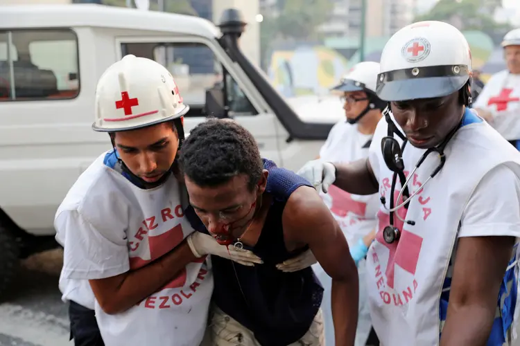 Manifestante ferido é socorrido pela Cruz Vermelha em protesto nesta terça-feira, 30 (Manaure Quintero/Reuters)