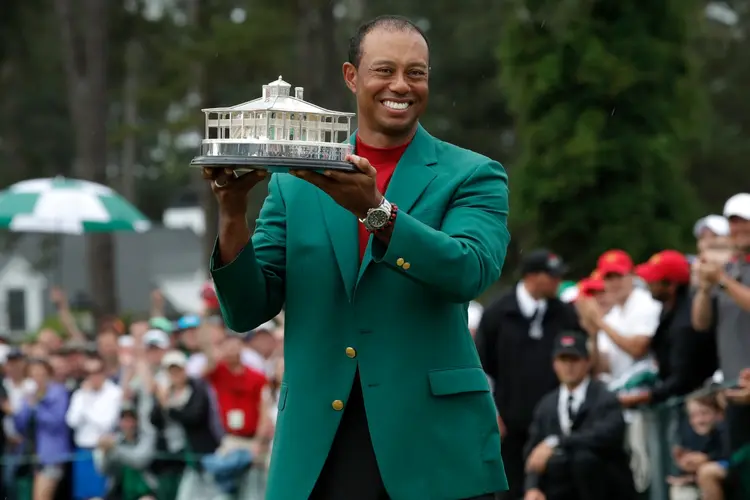 Tiger Woods com o cobiçado blazer verde e o troféu do Masters em sua última vitória no torneio, em 2019 (Mike Segar/Reuters)