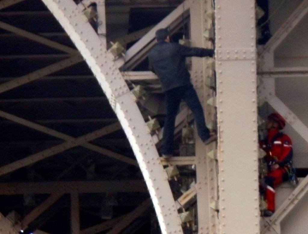 Homem escala a Torre Eiffel, que é fechada e evacuada