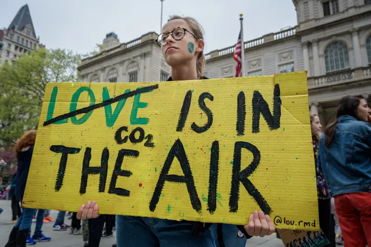 Garota com cartaz "CO² está no ar" durante protesto contra as mudanças climáticas em  NY, EUA: jovens se mobilizam para cobrar atitudes do governo (Erik McGregor/Pacific Press/LightRocket/Getty Images)