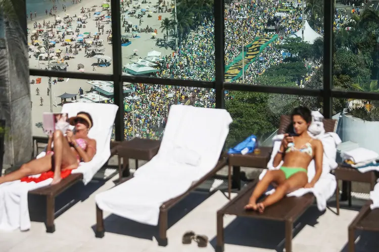 Ricos em uma cobertura na praia de Copacabana, no Rio, durante protesto pelo impeachment de Dilma Rousseff (Mario Tama / Staff/Getty Images)