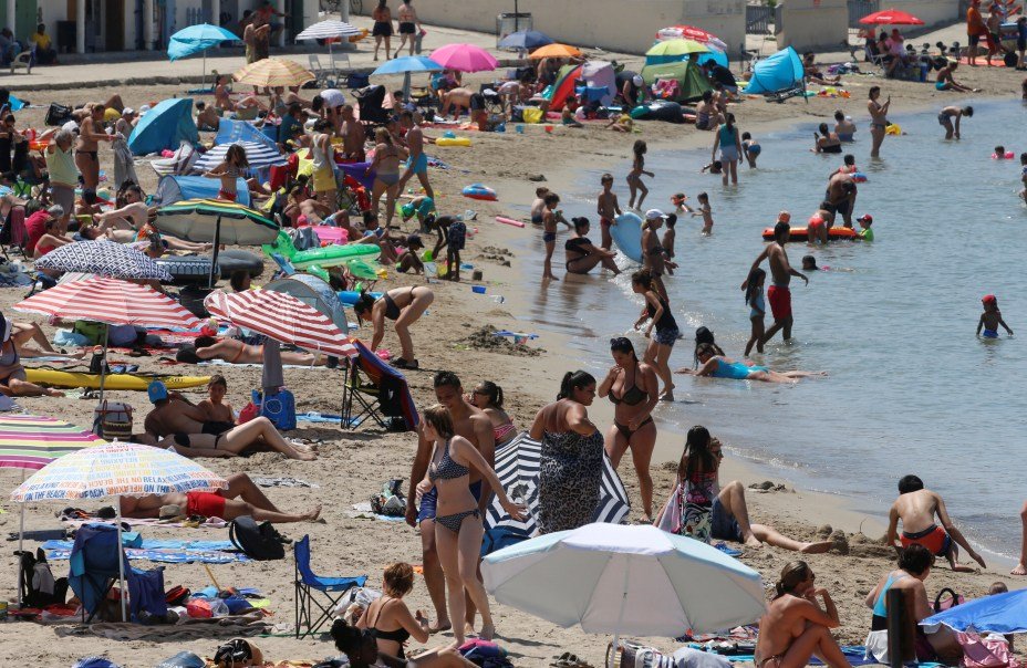 Praia cheia em Marseille, na França, durante verão europeu com forte onda de calor