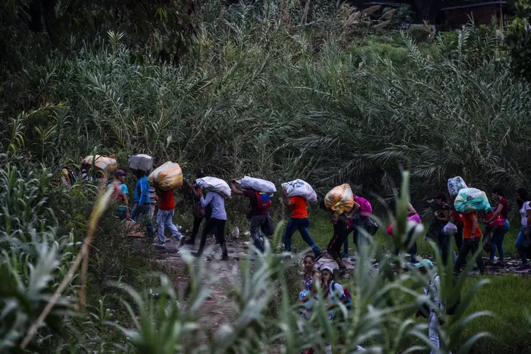 Colômbia: Venezuelanos cruzam a fronteira fugindo de uma crise política e econômica duradoura em sua terra natal que vem provocando uma escassez grave de alimentos e remédios (Federico Rios/Bloomberg)