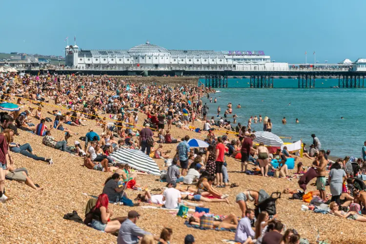 População de Brighton, Inglaterra, aproveita o tempo quente na praia durante o primeiro dia de Verão, no último sábado (Andrew Hasson/Getty Images)